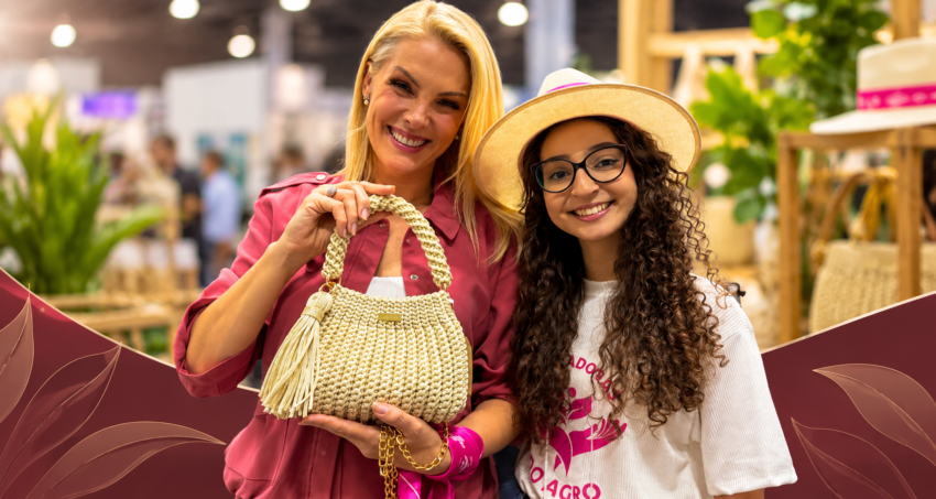 Mulheres exibem mala artesanal num mercado de artesanato